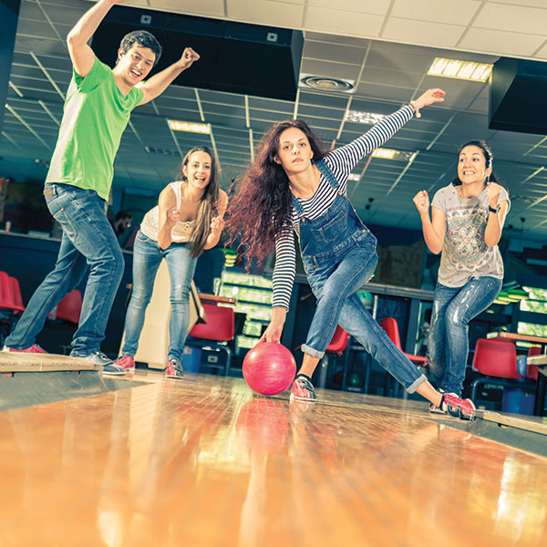 Youth friends bowling down lane